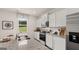Bright kitchen features stainless steel appliances, granite countertops, and white cabinets at 205 Friendship Oak Way, Hampton, GA 30228