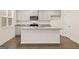 Modern kitchen showcases gray cabinets, stainless steel appliances, granite countertops and a large island at 205 Friendship Oak Way, Hampton, GA 30228