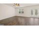 Comfortable living room with hardwood floors, double window, and patio door access at 205 Friendship Oak Way, Hampton, GA 30228