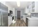 Kitchen with white cabinets, stainless steel appliances, and wood-look floors at 165 Nandover Way, Fayetteville, GA 30215