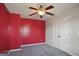 Red accent wall bedroom with carpet and ceiling fan at 2171 Grant Ave, Mcdonough, GA 30252