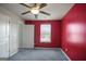 Bright bedroom with red accent wall, ceiling fan, and carpet at 2171 Grant Ave, Mcdonough, GA 30252