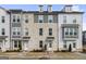 Three-story townhome with gray and white exterior, brick accents, and walkway at 295 Cobalt Dr, Fayetteville, GA 30214