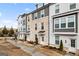Three-story townhome with gray and white exterior, brick accents, and walkway at 295 Cobalt Dr, Fayetteville, GA 30214