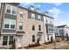 Three-story townhome with gray and white exterior, brick accents, and walkway at 295 Cobalt Dr, Fayetteville, GA 30214