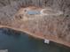 Aerial view of a cozy home with a private lake, surrounded by trees, offering serene waterfront living at 3505 Gum Creek Rd, Oxford, GA 30054