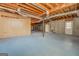 Unfinished basement with concrete flooring, exposed ductwork, and a white refrigerator at 3505 Gum Creek Rd, Oxford, GA 30054