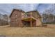 Backyard view of a brick home featuring a covered porch and serene natural surroundings at 3505 Gum Creek Rd, Oxford, GA 30054
