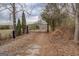 Private gated entrance with mature trees and gravel driveway leads to a secluded property at 3505 Gum Creek Rd, Oxford, GA 30054