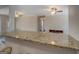 Open-concept kitchen with granite countertop bar and view to the Gathering room with ceiling fans at 3505 Gum Creek Rd, Oxford, GA 30054