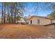 Wide backyard, and home, with deck visible through the trees at 210 Imad Ct, Fairburn, GA 30213