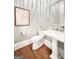 Elegant powder room with pedestal sink and hardwood floors at 500 Augusta Ln, Chattahoochee Hills, GA 30268