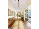 Bright hallway with hardwood floors, art, and a bench at 500 Augusta Ln, Chattahoochee Hills, GA 30268