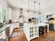 White kitchen features marble island, stainless steel appliances, and hardwood floors at 500 Augusta Ln, Chattahoochee Hills, GA 30268