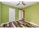 Spacious bedroom with ceiling fan, wood-look floors, and access to hallway at 2994 Meadow Wood Ct, Lawrenceville, GA 30044