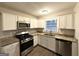Modern kitchen with white cabinets, granite countertops, and stainless steel appliances at 4303 Mercer Rd, Decatur, GA 30035