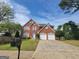 Brick home with two car garage and landscaped yard at 1345 Pinebreeze Way, Marietta, GA 30062