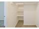 Spacious walk-in closet with white shelves and beige carpet providing a functional and organized storage solution at 1129 Winston Dr, Decatur, GA 30032