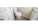 Bright bathroom with white toilet, wood-look flooring, and a glimpse of a granite vanity, showcasing modern style at 1129 Winston Dr, Decatur, GA 30032