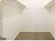 Walk-in closet with carpeted floor and white walls, offering ample storage space with shelving and hanging rods at 1129 Winston Dr, Decatur, GA 30032