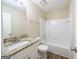 Bright bathroom with a granite countertop vanity and white tiled shower/tub combo at 1129 Winston Dr, Decatur, GA 30032
