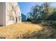 A spacious backyard of the home with sunlight, green grass, and mature trees at 1129 Winston Dr, Decatur, GA 30032