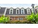 Charming exterior featuring a brick facade, dormer windows, lush landscaping, and mature plants at 12 Independence Nw Pl # 12, Atlanta, GA 30318