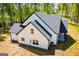 Aerial view of a home with white siding and black roof surrounded by a sparse lawn, showcasing its backyard and window placement at 90 Ayers Rd, Bowdon, GA 30108