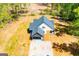 Aerial view of a home with white siding, a black roof, and a gravel driveway amid a sparse lawn at 90 Ayers Rd, Bowdon, GA 30108