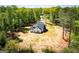Aerial view of a charming single-Gathering home nestled among lush trees, with white siding, a black roof, and a spacious lawn at 90 Ayers Rd, Bowdon, GA 30108