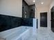 Luxurious bathroom featuring a sleek bathtub with black geometric tiling and modern fixtures at 90 Ayers Rd, Bowdon, GA 30108