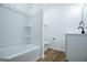 White bathroom includes a tub with tiled walls and a white vanity at 90 Ayers Rd, Bowdon, GA 30108