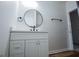 Modern bathroom featuring a white vanity with a round mirror and gold hardware at 90 Ayers Rd, Bowdon, GA 30108