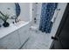Bathroom featuring white cabinets, marble counters and floors, and blue shower curtain at 90 Ayers Rd, Bowdon, GA 30108