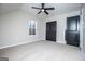 Neutral bedroom featuring carpeted floor, ceiling fan, closet with dark bi-fold doors, and a window at 90 Ayers Rd, Bowdon, GA 30108