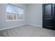 Cozy bedroom with a large window, plush carpet, and a dark-colored door for a modern touch at 90 Ayers Rd, Bowdon, GA 30108