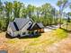 Stunning modern farmhouse with black roof and light siding surrounded by trees at 90 Ayers Rd, Bowdon, GA 30108