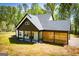 Charming home with a covered patio, open carport, wood-slat wall, and verdant lawn at 90 Ayers Rd, Bowdon, GA 30108