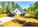 Aerial view of charming home with spacious yard, black roof and light siding at 90 Ayers Rd, Bowdon, GA 30108