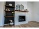 Close-up of the modern fireplace with wooden shelving and decor at 90 Ayers Rd, Bowdon, GA 30108