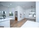 Bright living room featuring hardwood floors, large windows, and modern lighting fixture at 90 Ayers Rd, Bowdon, GA 30108