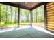 This covered patio boasts concrete flooring and peaceful views of the surrounding lush greenery and mature trees at 90 Ayers Rd, Bowdon, GA 30108