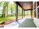 This covered patio boasts a ceiling fan, concrete flooring, and peaceful views of the surrounding lush greenery and mature trees at 90 Ayers Rd, Bowdon, GA 30108