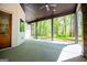 This covered patio boasts a ceiling fan, concrete flooring, and peaceful views of the surrounding lush greenery and mature trees at 90 Ayers Rd, Bowdon, GA 30108