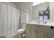 Well-lit bathroom with vanity, toilet, shower featuring a curtain, and large mirror at 147 Hubbard Rd, Woodstock, GA 30188