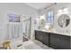 Elegant bathroom featuring dual vanities with modern fixtures, custom mirrors, and a linen closet at 147 Hubbard Rd, Woodstock, GA 30188