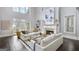 Spacious living room with fireplace, large windows, hardwood floors, and comfortable sofas at 147 Hubbard Rd, Woodstock, GA 30188