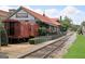 Exterior view of Freight Kitchen & Tap, featuring a vintage train car and outdoor dining, next to train tracks at 147 Hubbard Rd, Woodstock, GA 30188