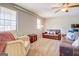 Living room features leather sofas, a ceiling fan, and large windows at 463 Conyers Rd, Mcdonough, GA 30253