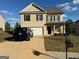 Two-story house with beige siding, attached garage, and landscaping at 385 Mcgiboney Ln, Covington, GA 30016